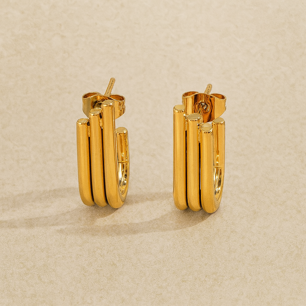 Pair of gold hoop earrings on a beige background