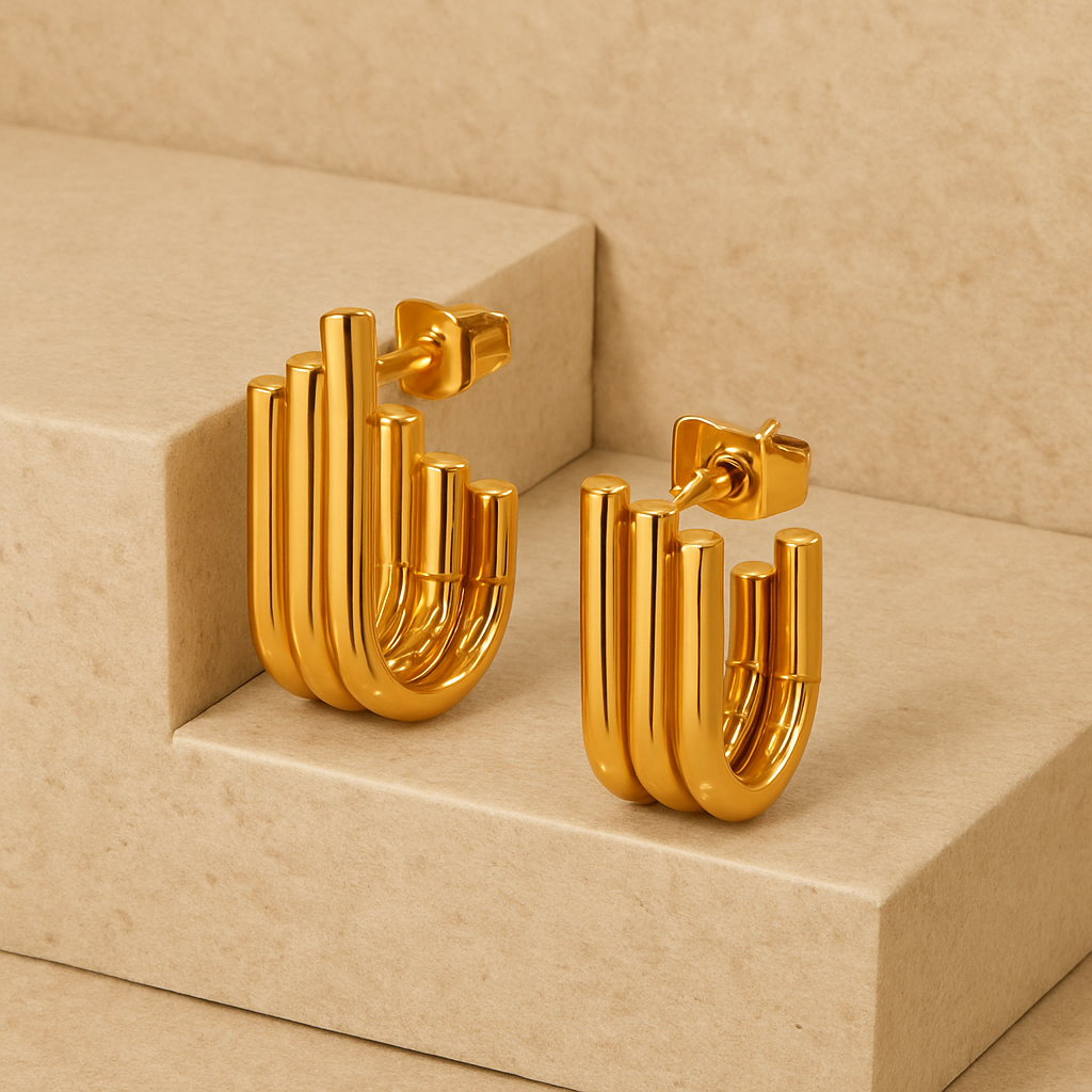 Gold hoop earrings on a beige platform