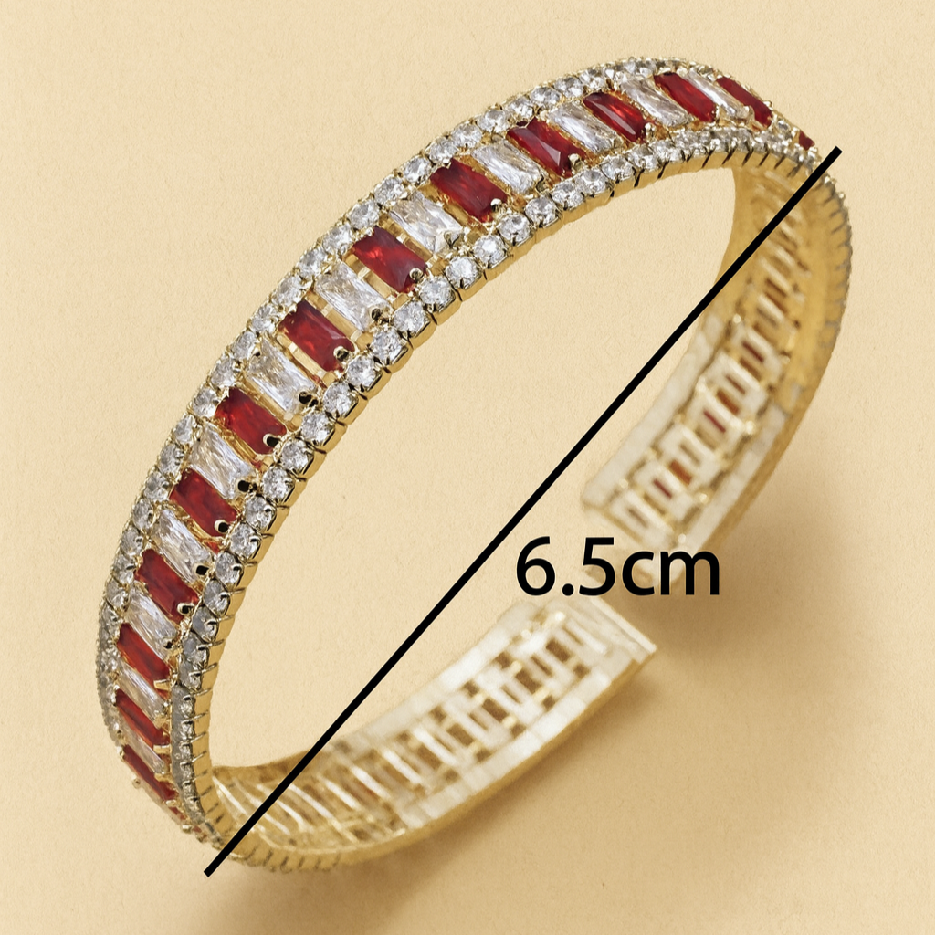 Gold bracelet with red stones and measurement details on a beige background