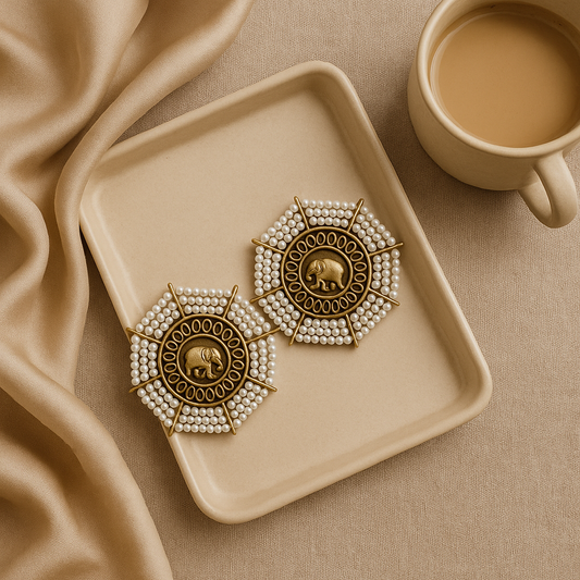 Decorative earrings on a beige tray with a cup of coffee