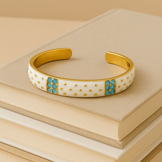 Gold bracelet with turquoise stones on a stack of beige books