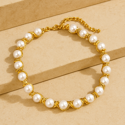Pearl bracelet with gold chain on a beige background