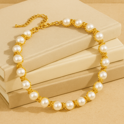 Pearl necklace with gold chain on beige background