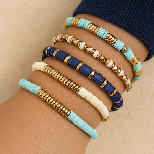 Set of colorful beaded bracelets on a wrist against a neutral background