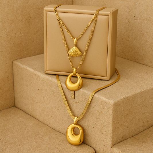 Gold necklaces on a beige box on a beige staircase