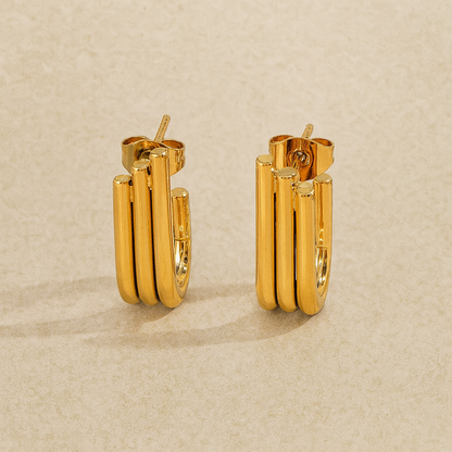 Pair of gold hoop earrings on a beige background