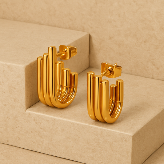 Gold hoop earrings on a beige platform