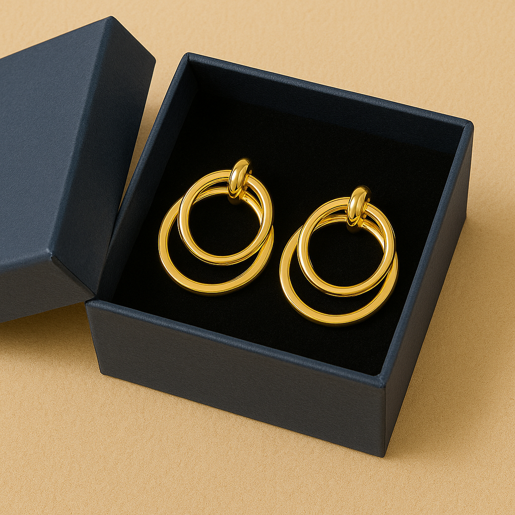 Gold hoop earrings in a black box on a beige background