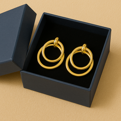 Gold hoop earrings in a black box on a beige background